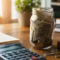 A savings jar filled with money symbolizing consistent daily saving and long-term wealth building.