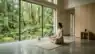 A person practicing mindfulness in a peaceful room with nature views, emphasizing a break from digital devices.