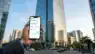 A visual representation of fractional real estate investment in a premium Indian commercial building via a mobile app. Representative Image