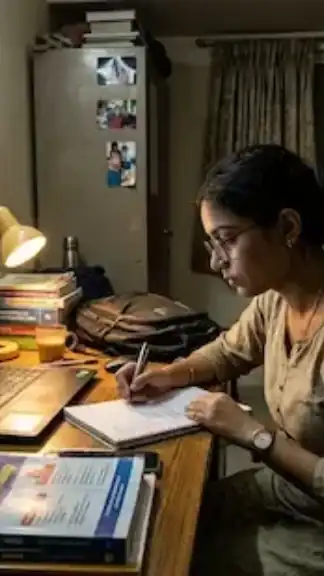 Indian college student studying late at night while managing scholarship applications and financial pressure inside a university hostel room.
