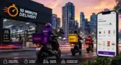 Electric delivery riders outside a modern dark store in an Indian city representing the rise of quick commerce and 10-minute delivery services in urban India.