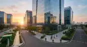 A sleek widescreen view of a modern, multi-story glass commercial tech park building in Navi Mumbai during early morning business hours representative image.