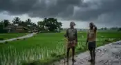 Farmers in rural India watching approaching monsoon clouds over agricultural fields during the start of the rainy season representative image.