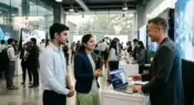 Young Indian graduates attending an AI-focused technology recruitment event in a modern corporate environment.