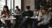 People sitting together in a café while individually focused on smartphones instead of real conversation.